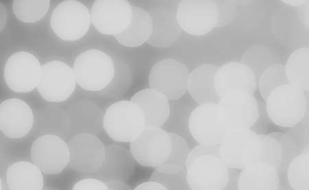 Soft colorful bokeh background. Luminous garlands of electric lights. Copy space to add text. Saturated colors. Blurry abstraction. Gentle grey monochrome tone. Dark night. Festive party.の写真素材