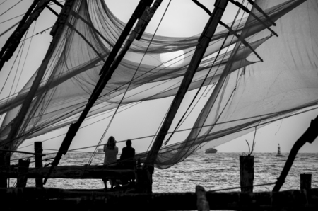 Chinese fishing nets on the shore of the Arabian Sea. Fort Cochin, Kerala, India. Historic Landmark. Warm evening. Scenic contours in the sunset twilight. Bright solar disk. Delicate juicy colors.の写真素材