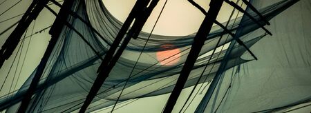 Chinese fishing nets on the shore of the Arabian Sea. Fort Cochin, Kerala, India. Historic Landmark. Warm evening. Scenic contours in the sunset twilight. Bright solar disk. Delicate juicy colors.の写真素材