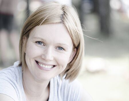 Portrait of young intelligent pretty woman. She is glad, happy and smiling. Summer picnic in the forest. Closeup, natural lighting and a blurred background.の写真素材
