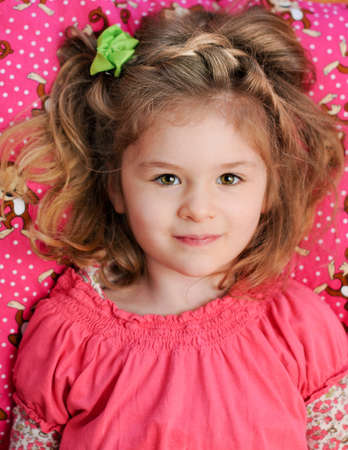 Beautiful Girl Reclining on Pink Pillowの写真素材