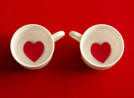 Two cups of coffee with hearts on red background. Flat lay, top viewの写真素材