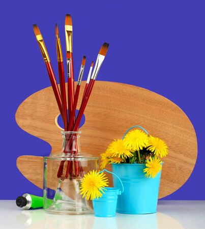 brushes with the palette and dandelionsの写真素材
