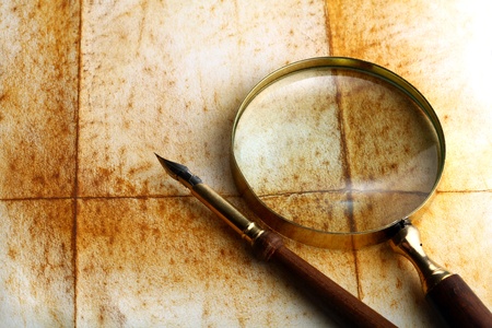 pen and magnifier  on old textured paperの写真素材