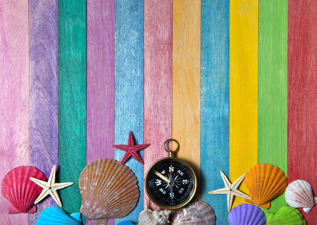 compass with sea shells on a colored wooden backgroundの写真素材