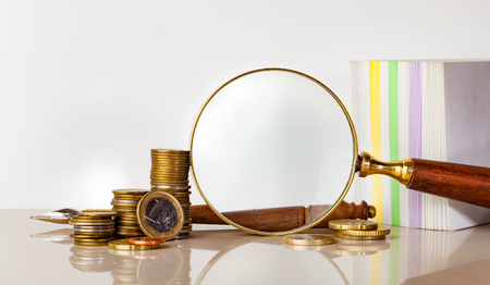 magnifying glass and coins for finance and banking conceptの写真素材