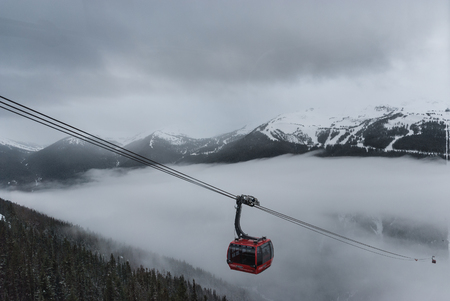 Cable car running between two snow covered mountains at a ski resortのeditorial素材