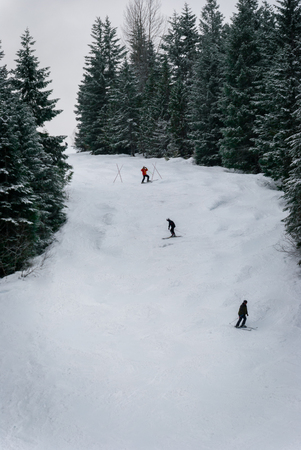 Aerial photo of a group of people skiing and snowboarding down runの写真素材