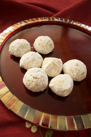 Buttery almond cookies on red mosaic tile plateの写真素材