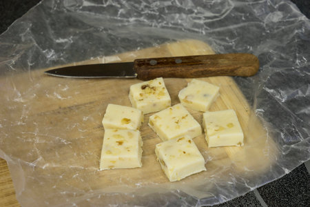 White chocolate fudge on wax paper and bamboo cutting boardの写真素材
