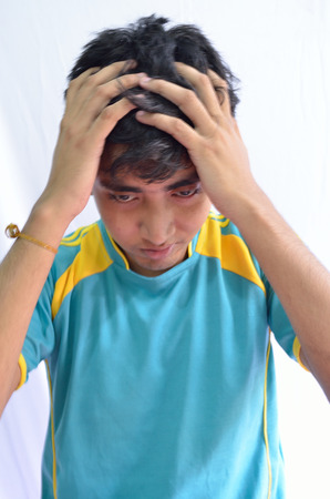 Young man tearinh his hairs with griefの写真素材