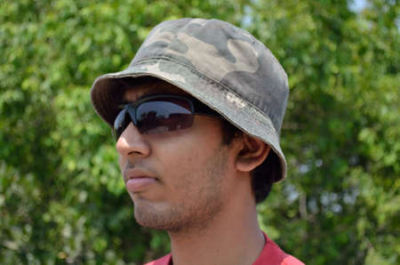 Young man wearing hat and sun-glass in a forestの写真素材