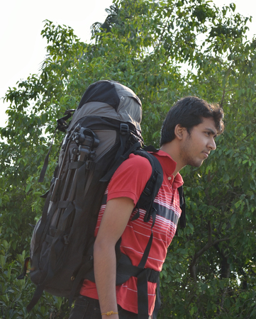 Young man with backpack on back ready to start journey