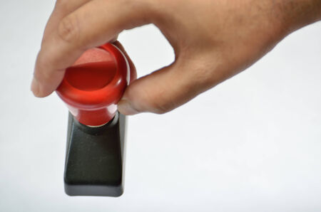 Stamp holding by human hand isolated on white backgroundの写真素材