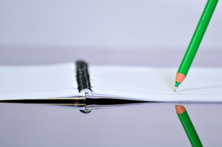 Pen pointed on notebook and reflected on tableの写真素材