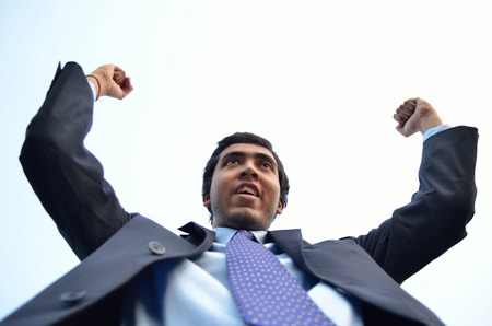 Successful businessman raised hand with accomplishmentの写真素材
