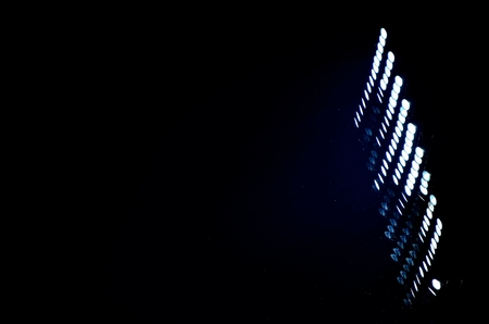 Stadium floodlights against a dark night sky background .の写真素材