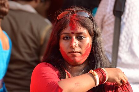 Portrait of young lady with red colour on face during celebration of last day of Durga Puja festivalのeditorial素材