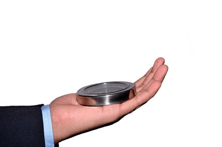 Man\'s hand in suit sleeve holding compass isolated on white background.の写真素材