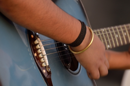 Close-up of a boy playing a guitar.の写真素材