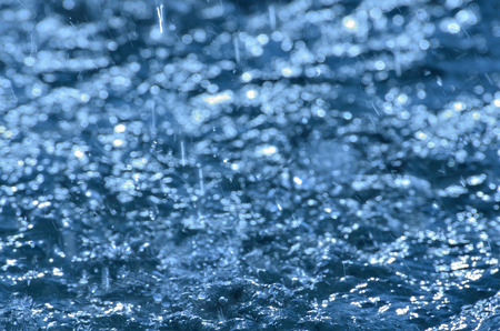 Rain drops on water.の写真素材