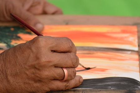 A man painting with brush in a canvas.の写真素材