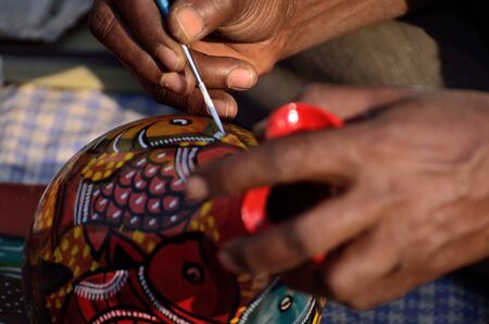 A man painting with brush.