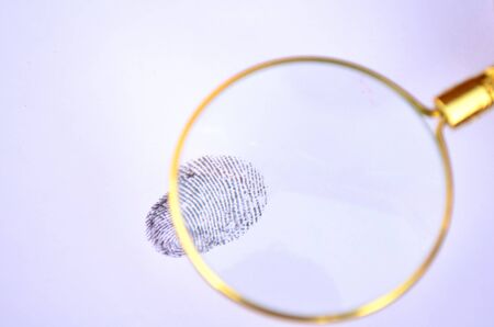 Magnifying fingerprint on isolated white background.