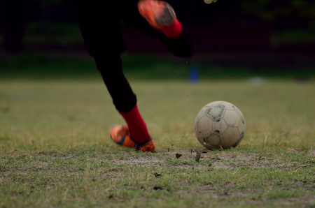 Boy is playing soccer in a ground. Boy kicks a soccer ballの写真素材