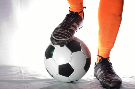 Player is receiving soccer ball in white background.