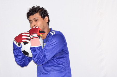 Soccer goalkeeper is holding a soccer ball.の写真素材