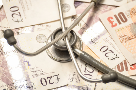 Healthcare and money concept image with currency and stethoscope.の写真素材