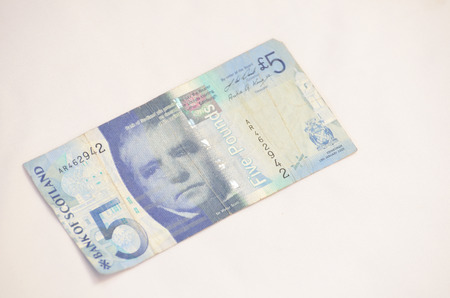 Single five pound British currency isolated on white background
