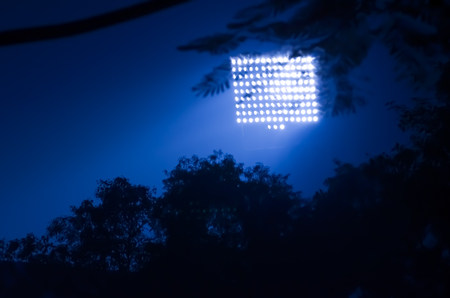 Stadium floodlights against a dark night sky background.の写真素材