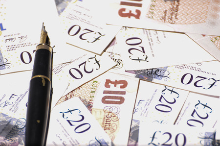 Close up of British currency notes and fountain pen.の写真素材