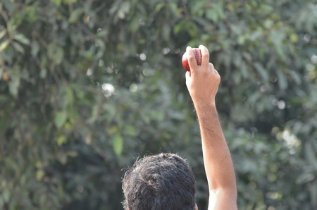 Boys are playing cricket. Fast bowling grip.