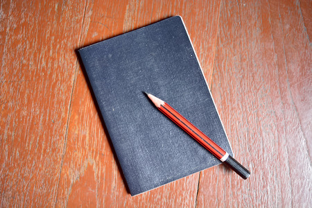 Notepad with pencil on table.