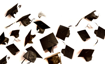 graduation cap is flying on white backgroundの写真素材