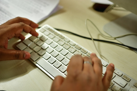 Office worker typing on a bit dirty keyboard