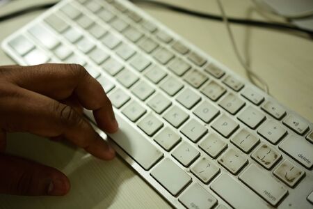 Office worker typing on a bit dirty keyboard