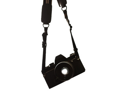 Old black camera hanging on white backgroundの写真素材
