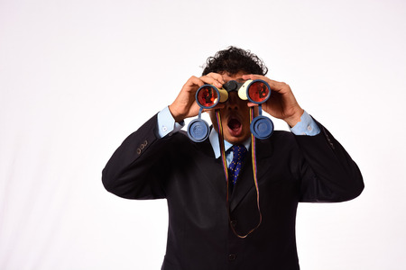 Businessman looking through binocularの写真素材