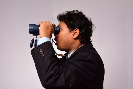Businessman looking through binocularの写真素材