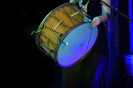 Girl playing drum in a music concert on black backgroundの写真素材
