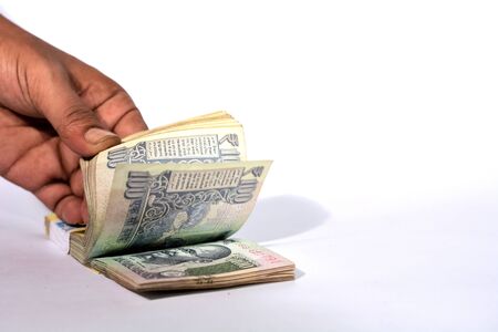 Counting one hundred rupees on white backgroundの写真素材