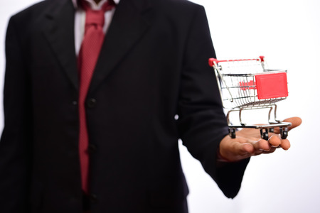 Shopping cart and businessman on white backgroundの写真素材