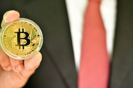 Unrecognizable person holding golden color bitcoin