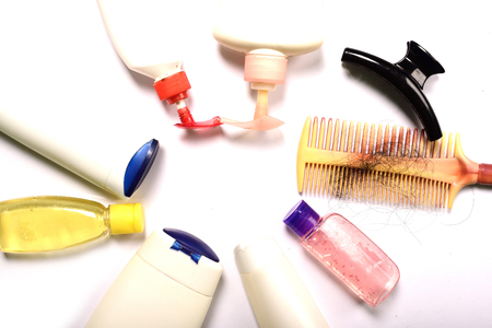 Comb with hair and shampoo bottles on white backgroundの写真素材