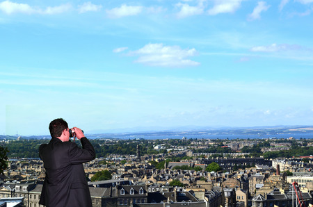 Business Man is spying with Binoculars on Competitorsの写真素材