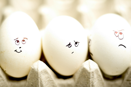 Eggs with funny faces on egg tray